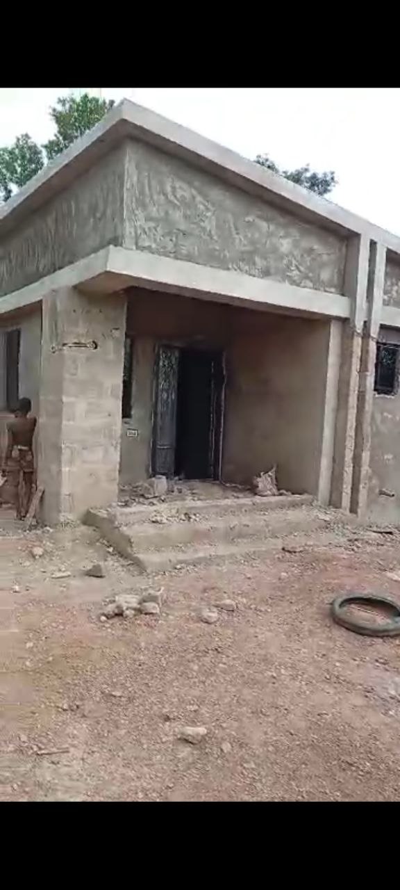 N-SOL Construction delivering four-bedroom residential bungalow in Ogidi, Anambra State, showing exterior porch, parapet roof design, and entrance steps during finishing stage.